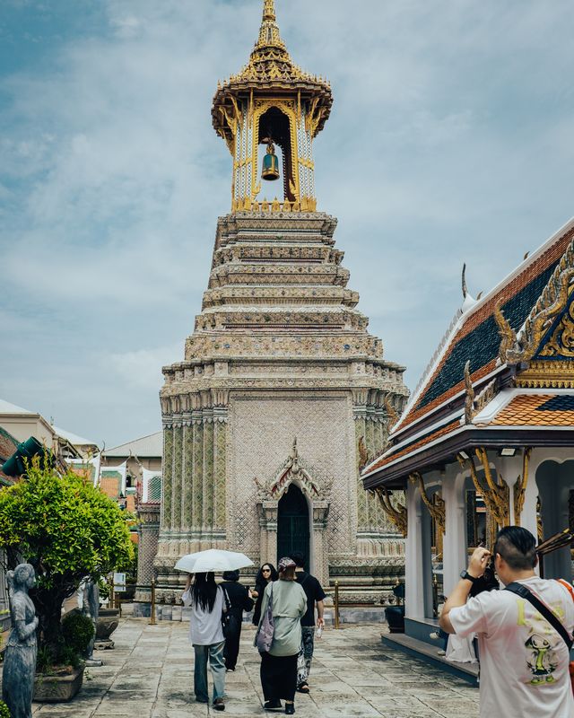 A white stupa with a golden spire in a temple courtyard.