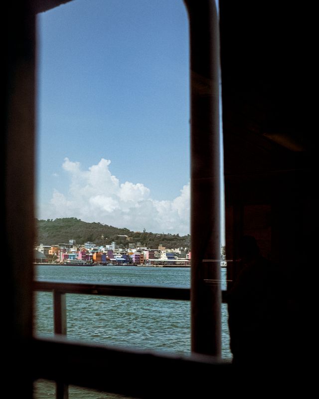The sea seen through a window, with the horizon framed by glass.