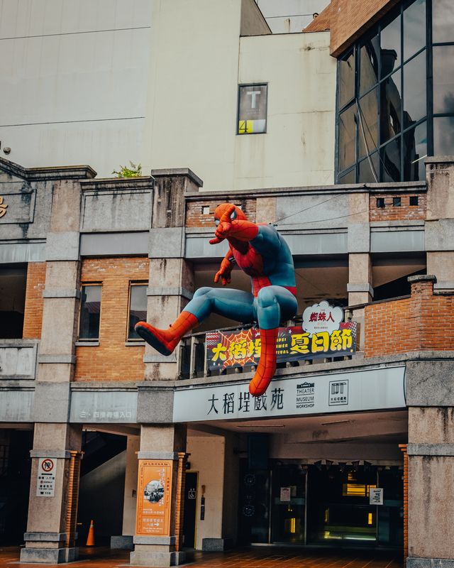 A Spiderman figure on a wall above a Taipei street.