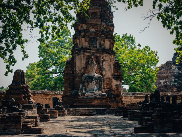 A seated Buddha statue among the brick ruins of Ayutthaya.