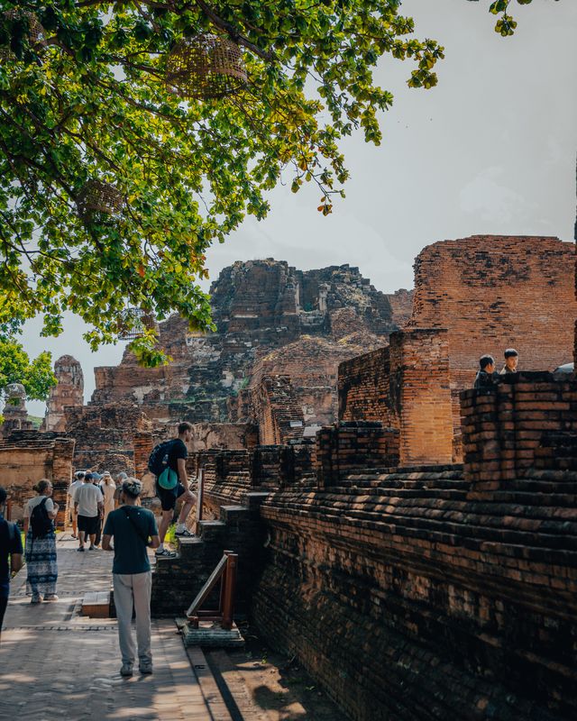 Visitors walking among the ruins of Ayutthaya.