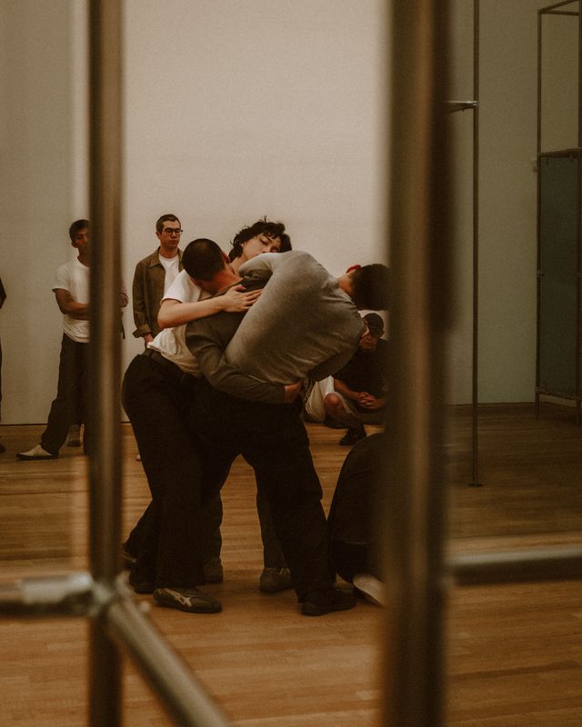 Dancers rehearsing in a mirrored studio.