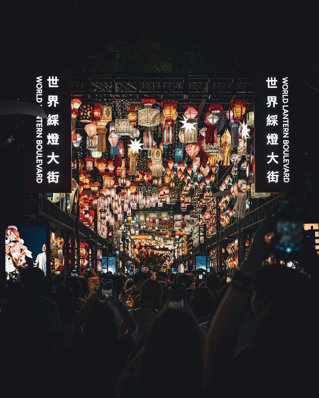 A dense row of colourful lanterns hanging above the street.