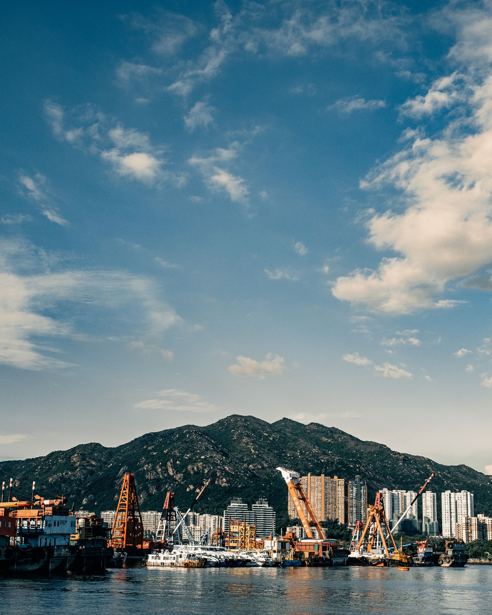 The Hong Kong skyline across the harbour in late afternoon light.