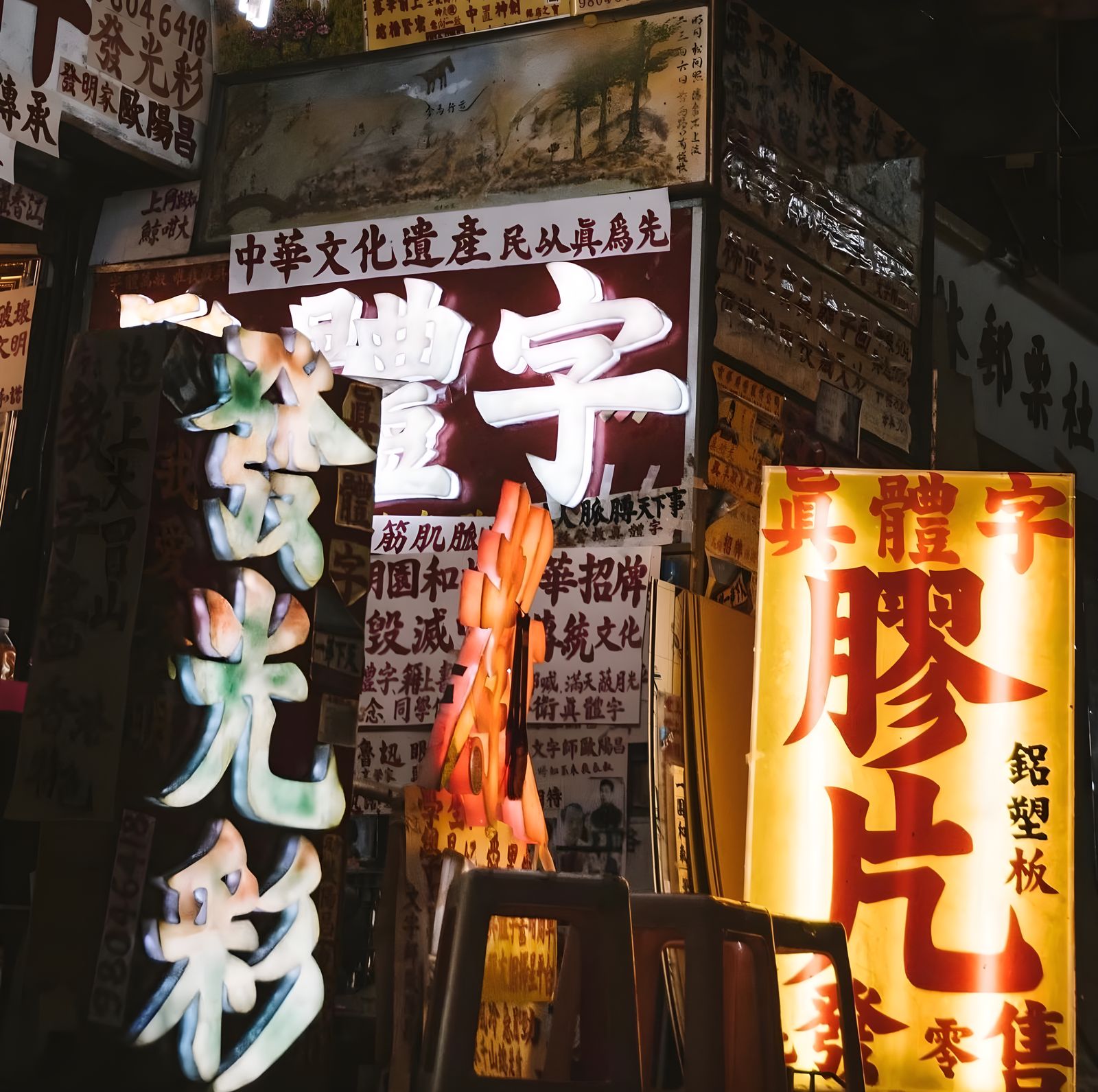 Neon signs and a lit shop entrance after dark in Hong Kong.