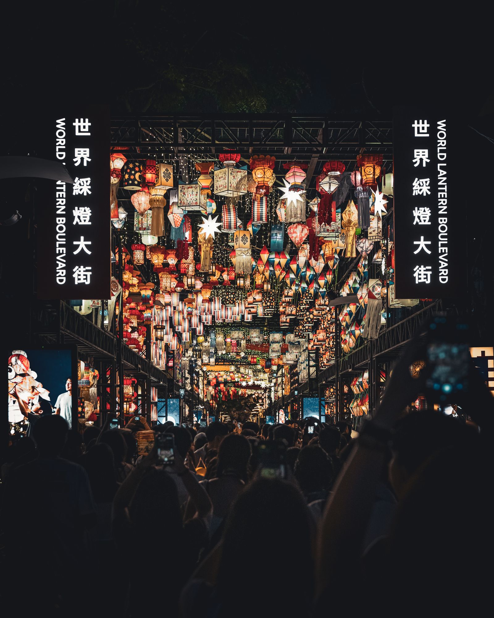 A dense row of colourful lanterns hanging above the street.