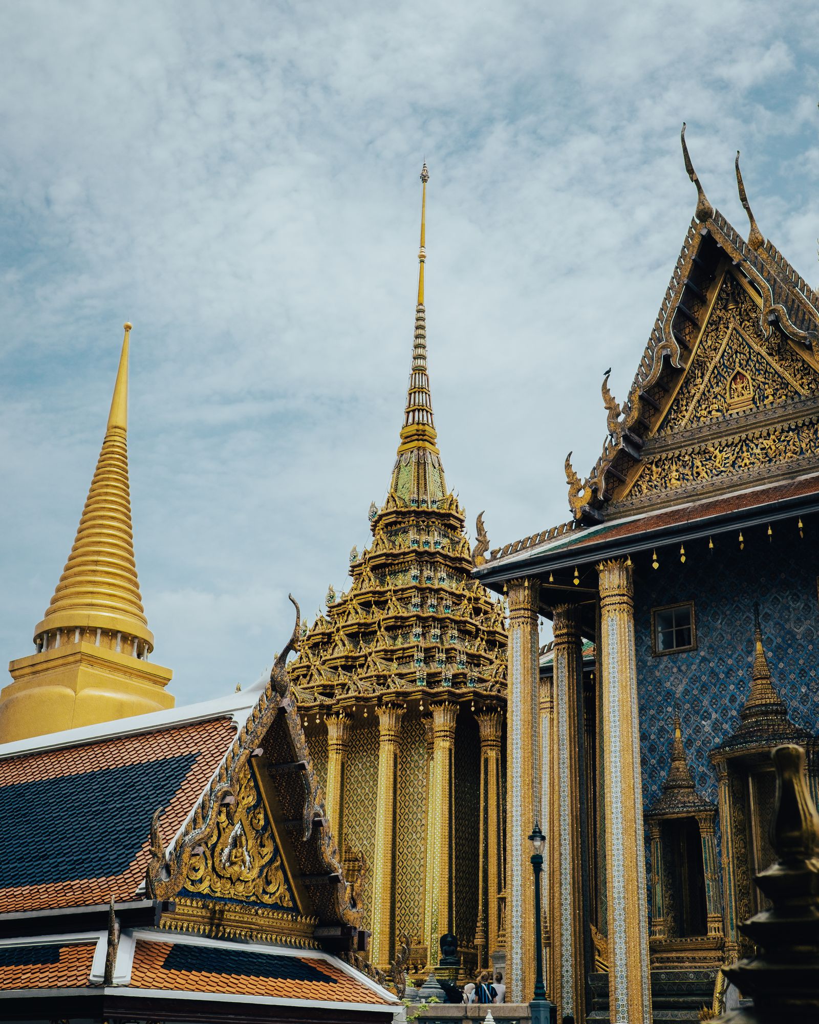 Layered temple roofs and golden spires against a pale blue sky.