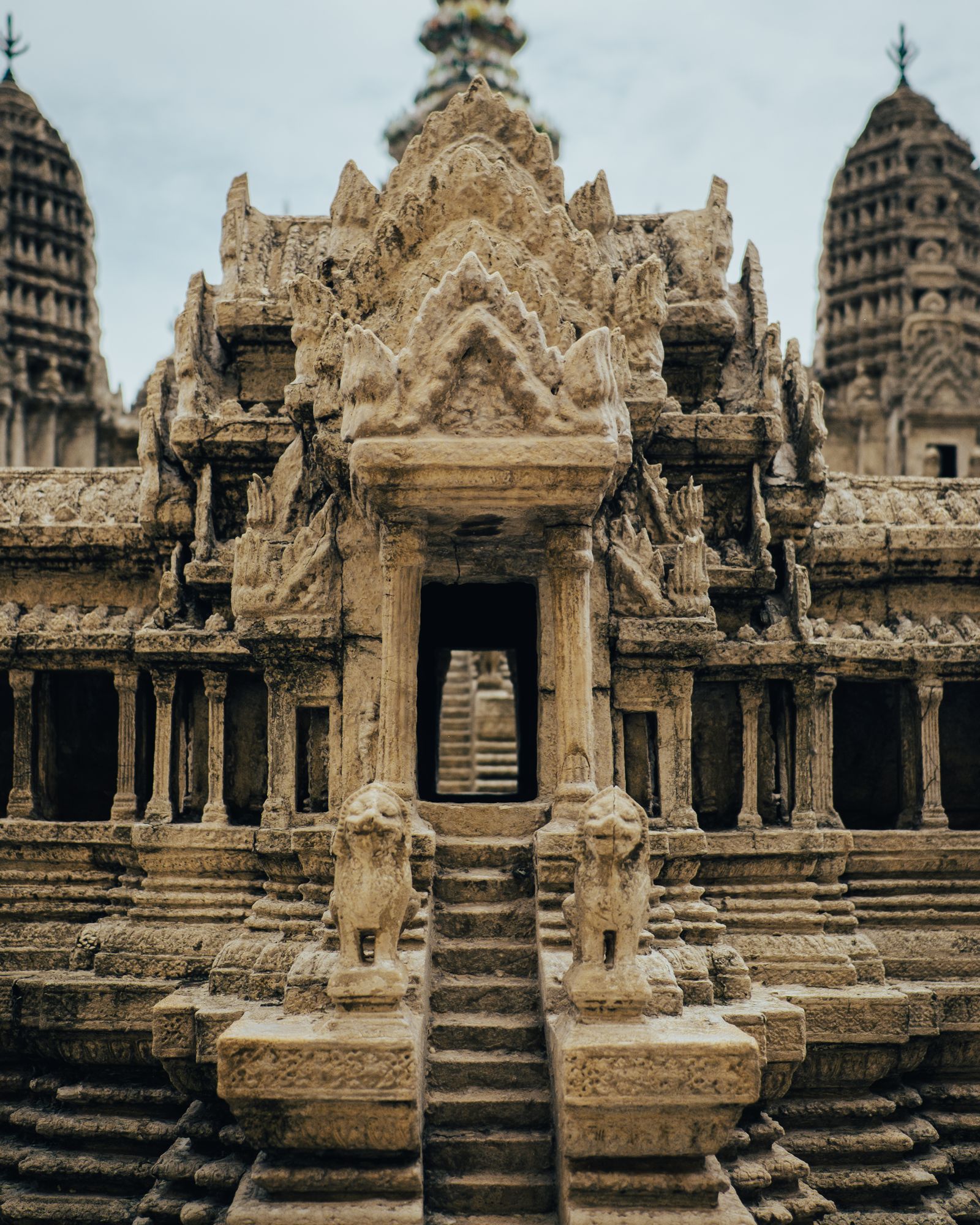 An intricately carved stone temple facade with guardian figures and tiered spires.