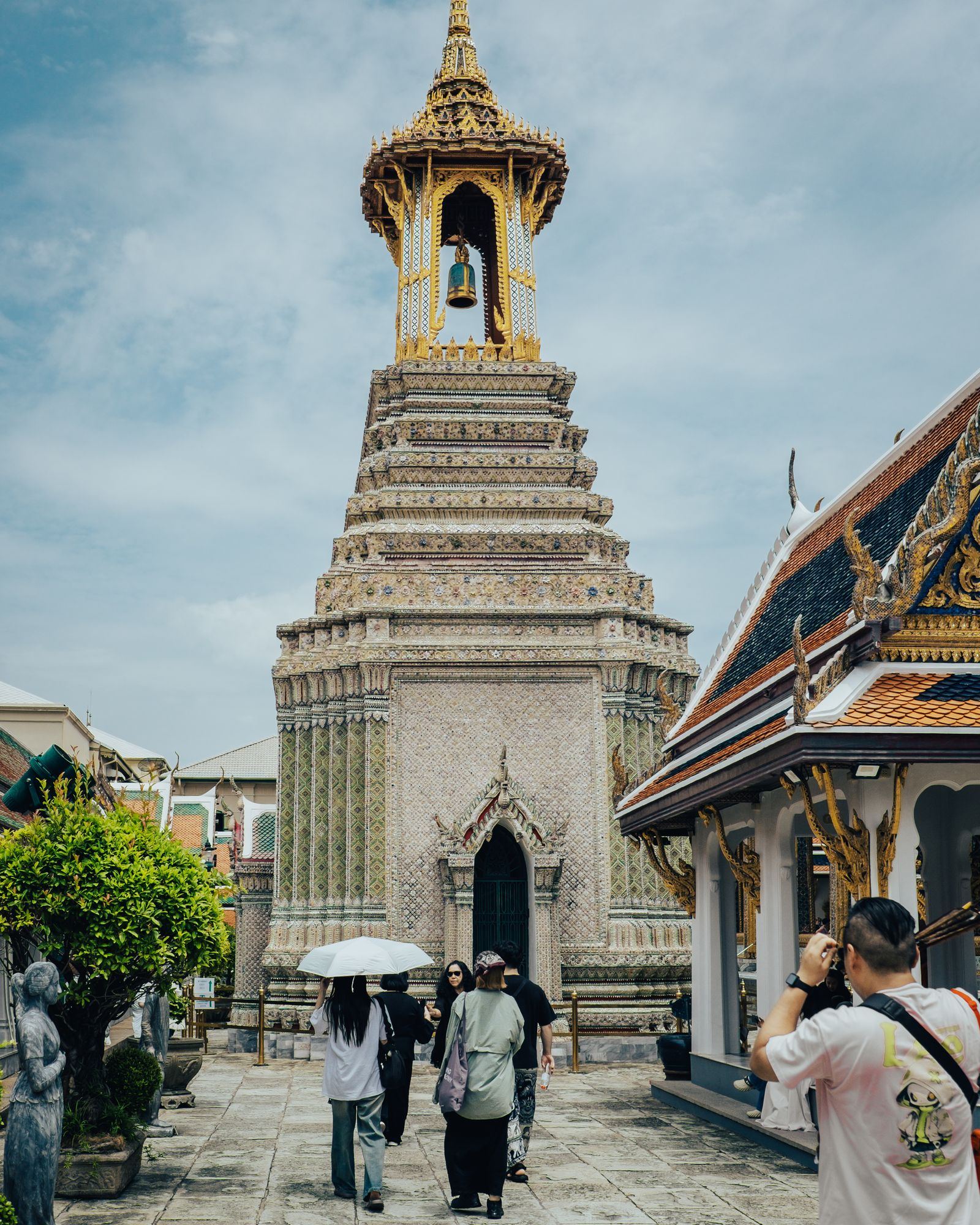 A white stupa with a golden spire in a temple courtyard.