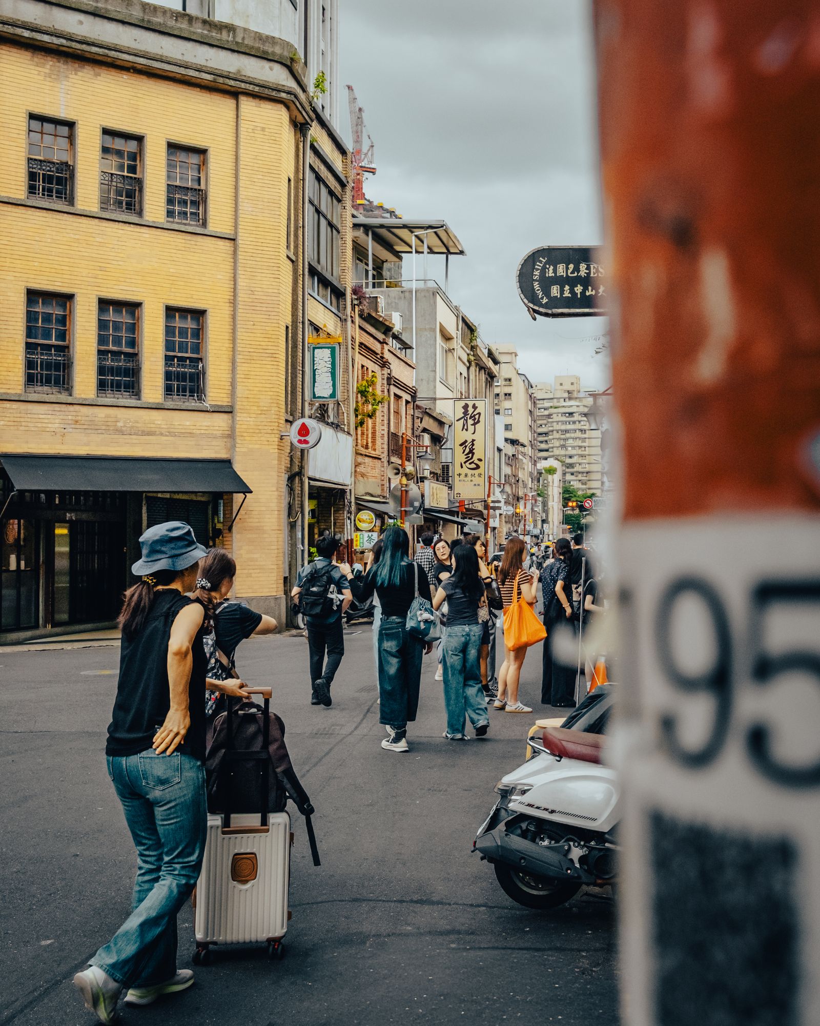 Pedestrians crossing a busy Taipei street.