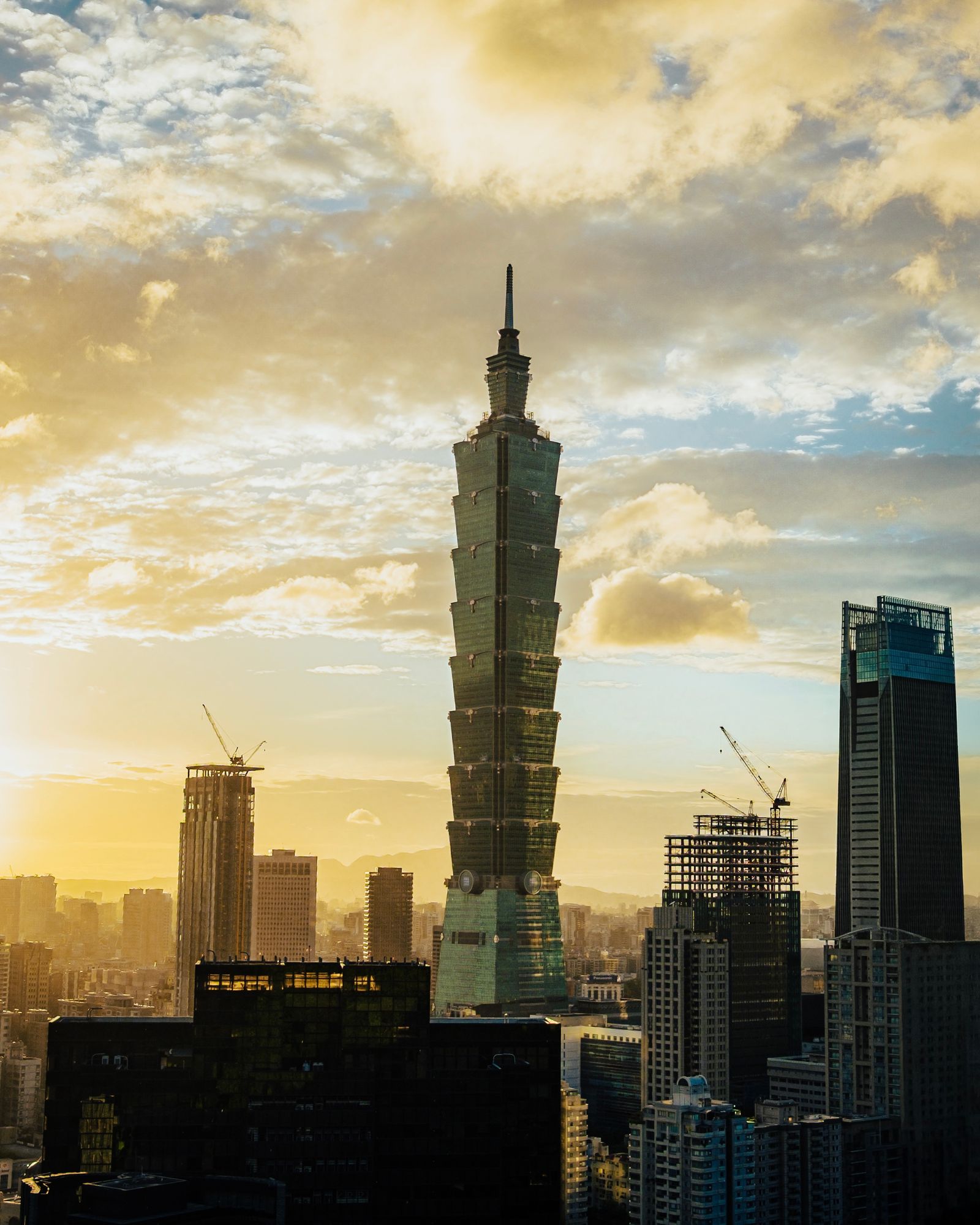 Taipei 101 at sunset, with warm light across the sky.